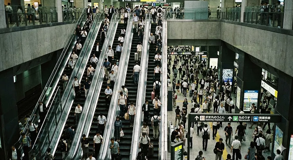 Busy underground escalators at Tokyo Station during rush hour